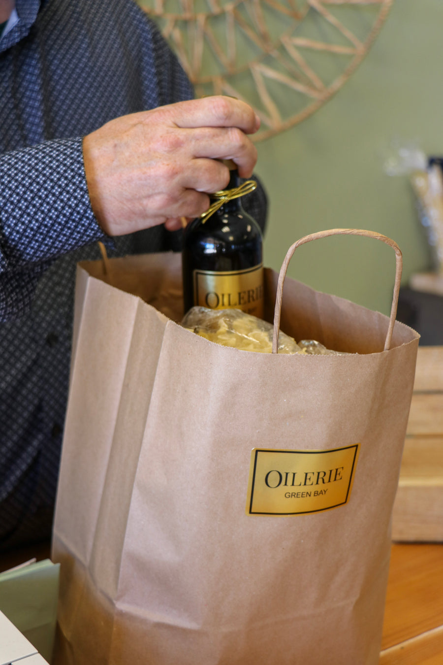 A freshly filled bottle going into an Oilerie bag